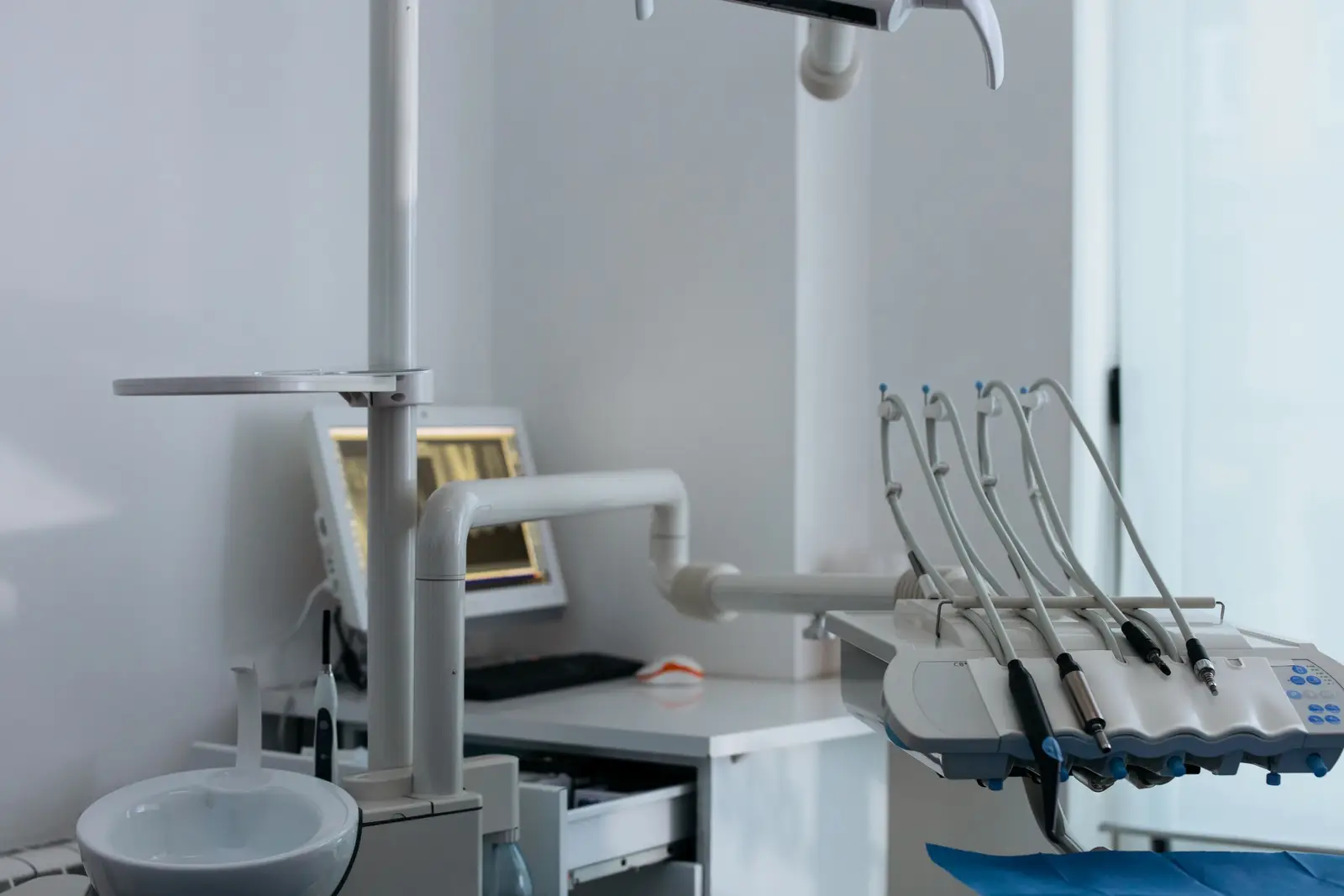 A quiet, bright dental operatory with instruments arranged on the tray